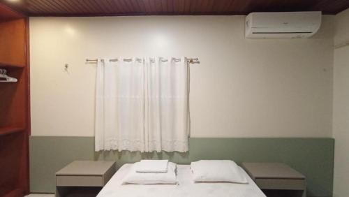 a room with a bed and a shower curtain at Hostel Angatu Manaus in Manaus