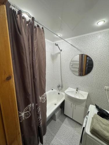 a bathroom with a shower curtain and a toilet and a sink at Затишна квартира на березі Дніпра in Cherkasy