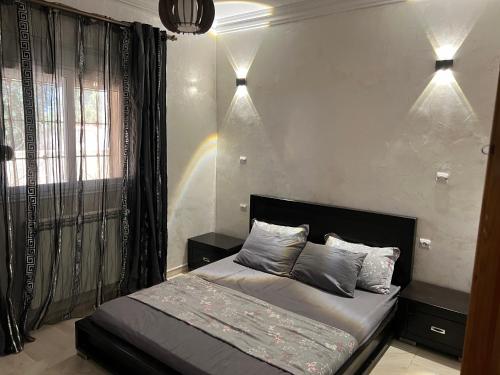 a bedroom with a bed and two lights on the wall at Villa Caprosa à côté du lac in El Kala