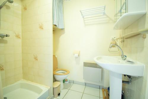 a white bathroom with a sink and a toilet at Le Petit Bleu I Magnifique vue mer & Plage à 50m in Crozon