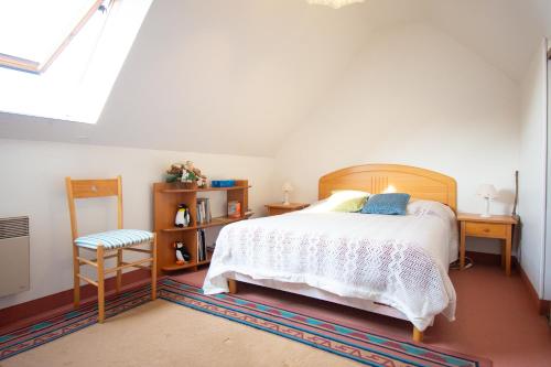 a bedroom with a bed and a table and a chair at Le Petit Bleu I Magnifique vue mer & Plage à 50m in Crozon