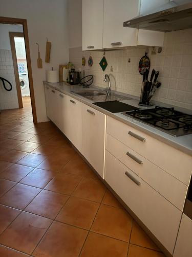 a kitchen with white cabinets and a stove at PM 16 Via Frati de Addis in Aggius
