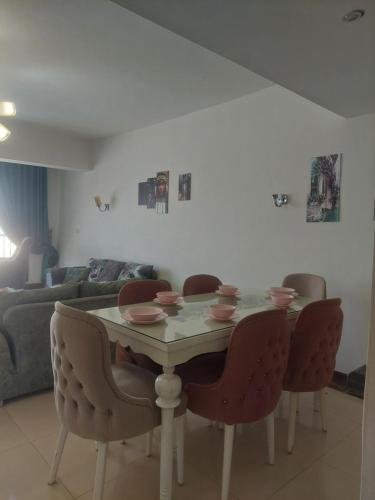 a dining room table with chairs and a couch at بورتو كايرو التجمع الخامس in Cairo