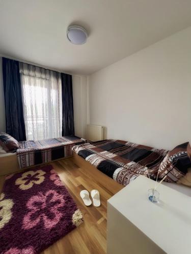 una camera da letto con due letti e un tappeto di AriApartament a Kosovska Mitrovica