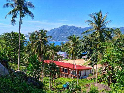 a house with a red roof and palm trees at Koh Tao -Tropical Apartments in Koh Tao