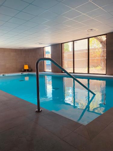 a swimming pool with a rail in the water at Nemea Appart Hotel Coeur Europe Strasbourg Illkirch in Illkirch-Graffenstaden