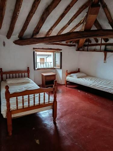 a room with two beds and a window in a building at Casa de pelegrinos la perlanegra 