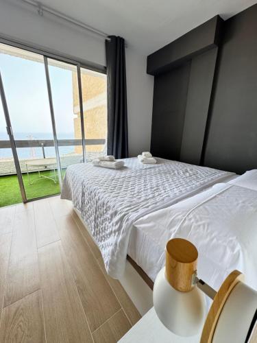 ein Schlafzimmer mit einem Bett mit Blick auf das Meer in der Unterkunft Tabaiba Modern & Bright Apartment Sea View in Tabaiba