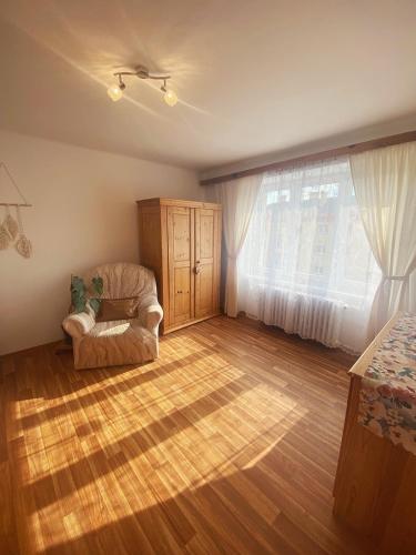 Una sala de estar con una silla y una ventana. en Apartmán v Trutnově, en Trutnov