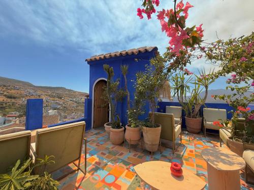 a patio with tables and chairs and potted plants at Casa Amina in Chefchaouene
