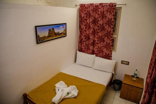 a small bed in a room with a window at Maison Blanche DK in Puducherry