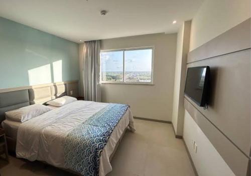 a bedroom with a bed and a flat screen tv at Aqualand resort in Ilha de Atalaia