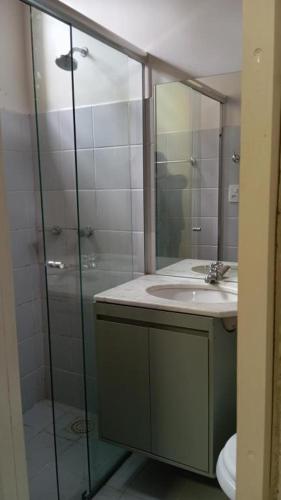 a bathroom with a sink and a glass shower at Hostel Angatu Manaus in Manaus