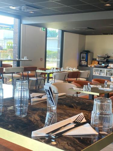 a dining room with tables and chairs in a restaurant at Nemea Appart Hotel Coeur Europe Strasbourg Illkirch in Illkirch-Graffenstaden