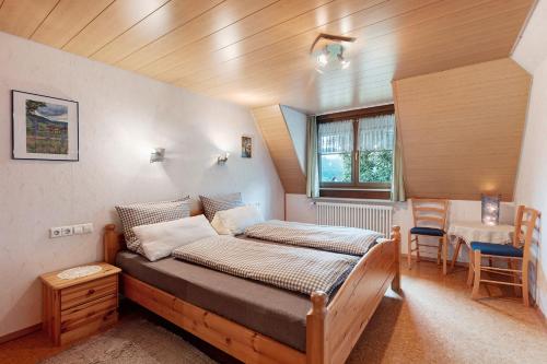 a bedroom with a bed and a table and chairs at Ferienwohnung Schweizer in Bernau im Schwarzwald