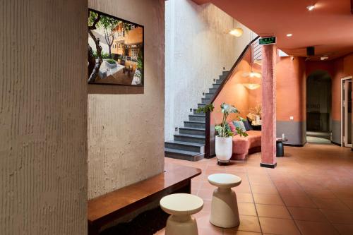 a lobby with a staircase and two stools at Kin Wander Tân Phong, The Moonage in Ho Chi Minh City