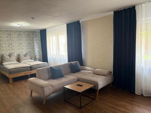 a living room with a couch and a bed at 1-Zimmer-Apartment mit Pool und Kamin in Ellenz-Poltersdorf