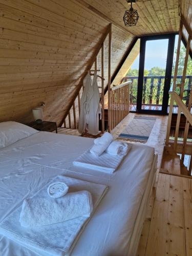 a bed in a wooden room with towels on it at Cozy Cottage B in Kutaisi