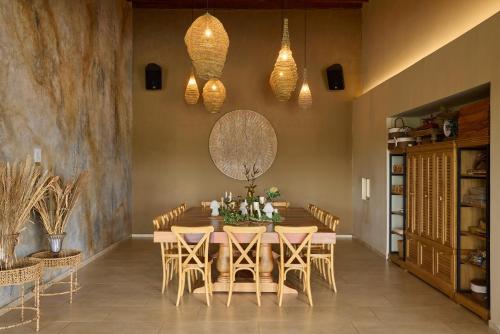 a dining room with a wooden table and chairs at Tau House in Guatapé