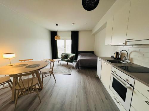 a kitchen and living room with a table and a couch at Kiva yksiö kahdelle in Turku