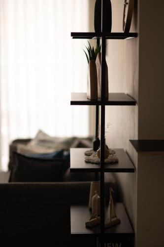 a shelf with shoes on it next to a bed at Family Apartment By IsrApart in Ramat Gan