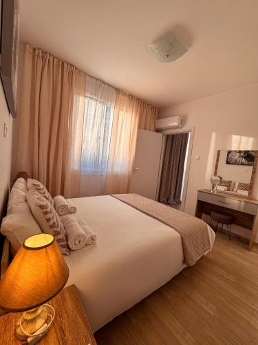 a bedroom with a bed and a desk with a lamp at Cozy & Stylish 1Bedroom Apartment in Limassol
