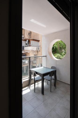 a dining room with a table and chairs and a window at Family Apartment By IsrApart in Ramat Gan