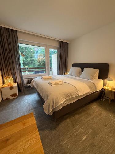 a bedroom with a large bed with a large window at Irmella 9 by Arosa Holiday - new renovated in Arosa
