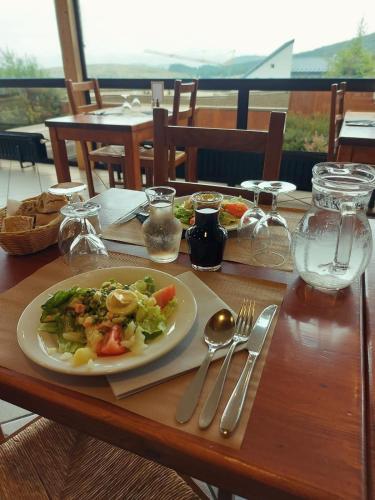a wooden table with a plate of food on it at Gergovia in Super Besse