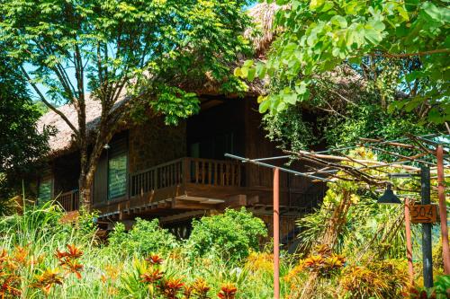 a house with a deck in the yard at Mai Chau Ecolodge in Mai Chau