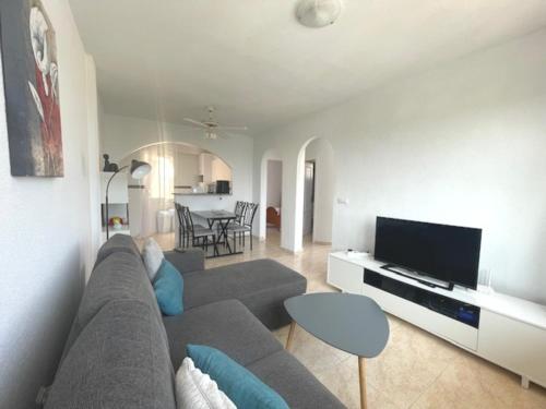 a living room with a couch and a tv at Playa Flamenca 2 bed Apt Sol De Mar in Villamartin