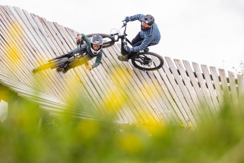 two people riding bikes on a fence at Deluxe Apartment - Sauna & Pool - Free Parking in Winterberg