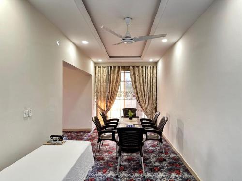 a dining room with chairs and a table and a window at Ziel Hotels & Guest House Islamabad Near US Embassy & VFS Global in Mohra Nūr