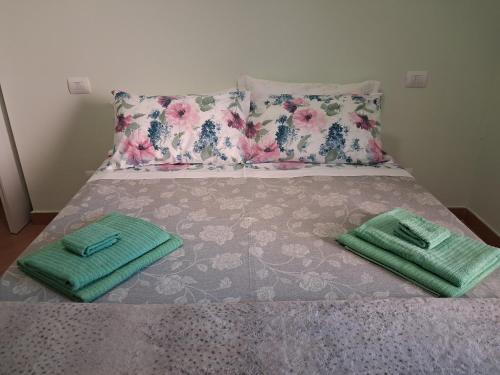 a bed with two green towels sitting on it at Imperiale in Sarzana