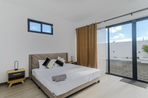 a bedroom with a bed and a large window at Rocky 39 in Grand-Baie