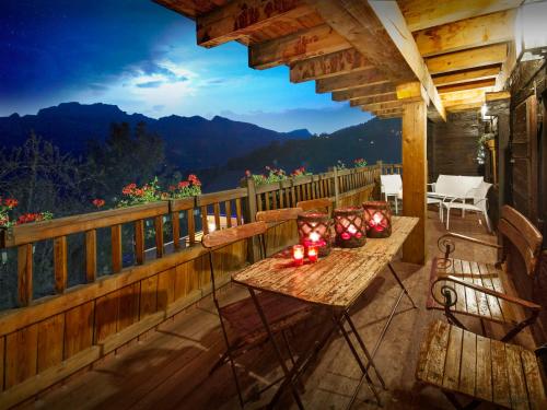 a patio with a table and chairs on a balcony at Chalet Le Meridien Etale - OVO Network in Manigod
