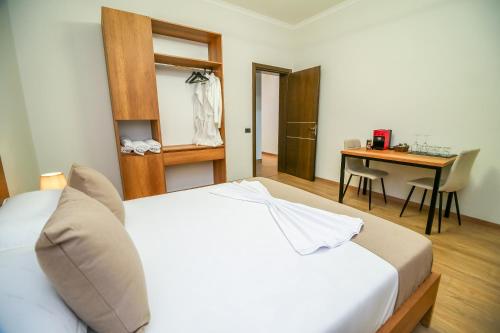a bedroom with a white bed and a desk at The Blue House in Široka