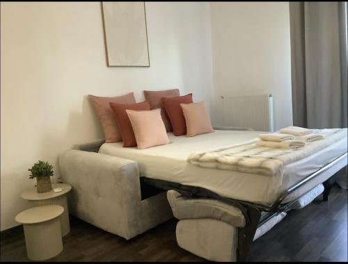 蒙泰夫兰Suite Oceïna Proche Disneyland Parking 4 Pers的客房内的一张带枕头的床铺和一张沙发