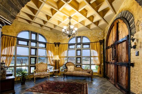 a living room with a chandelier and large windows at Vineam Castle - Manor Guesthouse in George