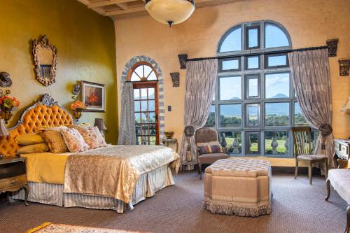 a bedroom with a bed and a large window at Vineam Castle - Manor Guesthouse in George