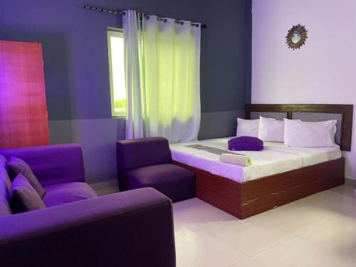 a bedroom with a bed and a chair and a couch at LLOYDS BEACH RESORT and SPA in Kokrobite