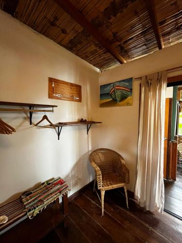 a room with a chair and a table and a window at Casa Kresala, Surf House in Zorritos