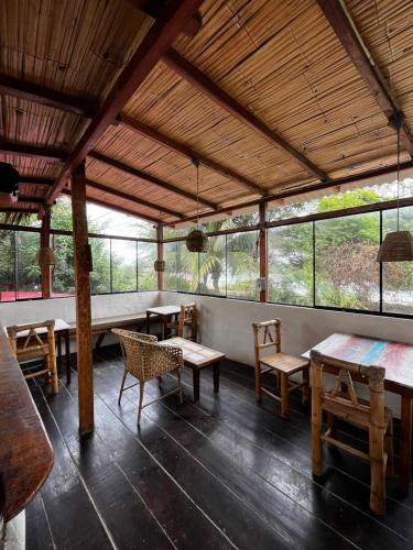 a room with tables and chairs and windows at Casa Kresala, Surf House in Zorritos