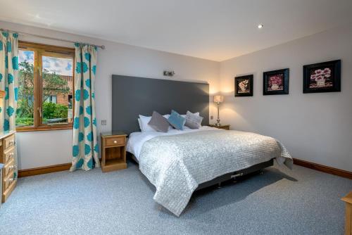 ein Schlafzimmer mit großem Bett und Fenster in der Unterkunft Yew Cottage in Boston