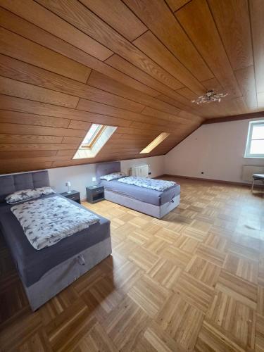 a large bedroom with two beds and a wooden ceiling at Wohnung Maric bis zu 10 Personen in Neunburg vorm Wald