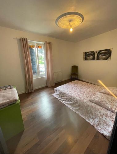 a bedroom with a large bed and a window at La Savoureuse in Belfort