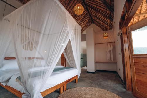 a bedroom with a bed with white mosquito nets at Foot On Africa Safari Lodge in Mto wa Mbu