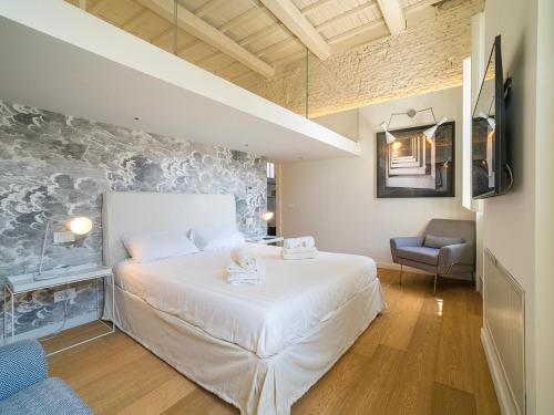 a bedroom with a large white bed and a chair at LUXURY Terrazza Privata su Fontana di Trevi in Rome