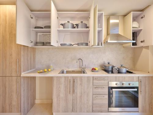 a kitchen with white cabinets and a sink at Boutique Residence Mangroovy-Lemon Spaces Gouna in Hurghada
