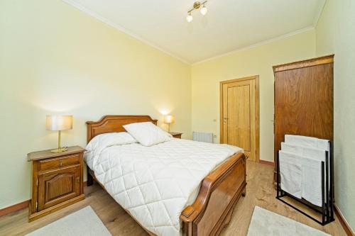 a bedroom with a bed and a night stand with a lamp at Casa Carvalhal do Esporão in Lamalonga